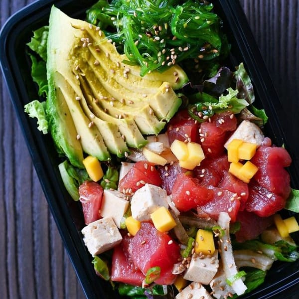 A Tiger Plate poke bowl with tuna, tofu, mango, avocado, seaweed, and sesame seeds.