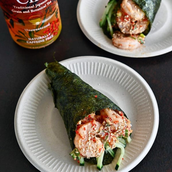 Two Tiger Plate shrimp poke hand rolls with cucumber and roe, and a bottle of unsweetened tea.
