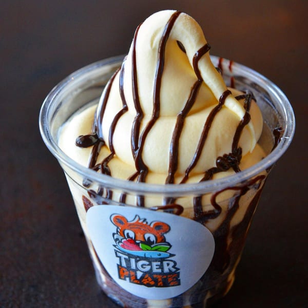 Tiger Plate's soft serve ice cream with chocolate drizzle in a clear cup.