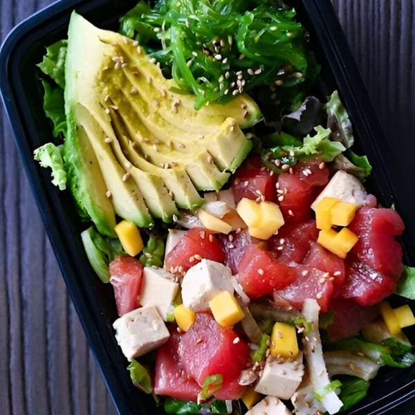 Tiger Plate poke bowl with tuna, tofu, mango, avocado, seaweed, and sesame seeds.